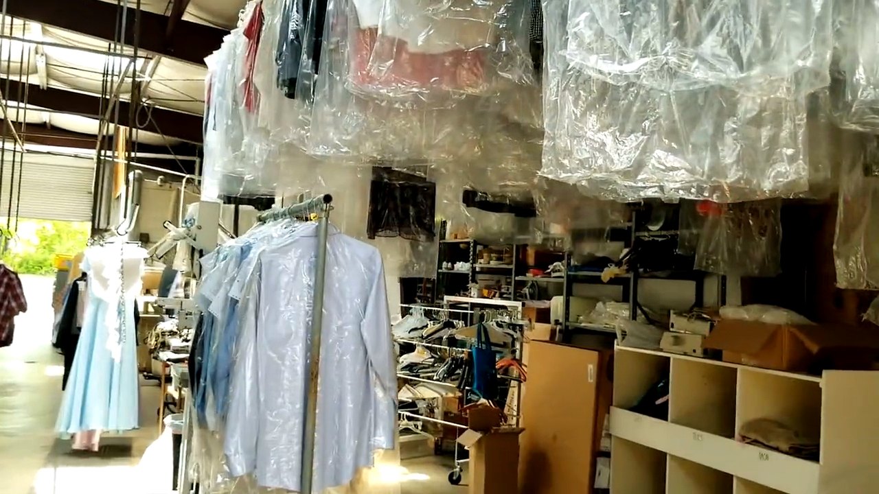 Cleaned garments hanging in plastic ready for collection